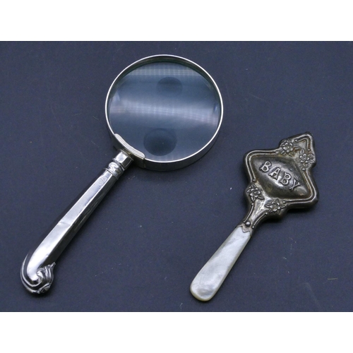 300 - A Sheffield silver handled table magnifying glass and a Chester silver baby's rattle with Mother of ... 