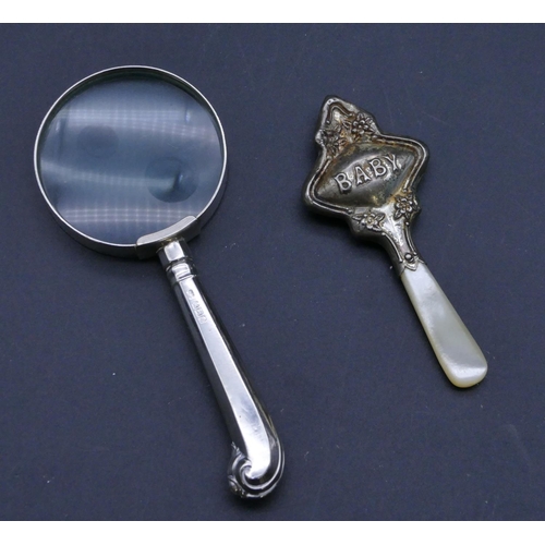 300 - A Sheffield silver handled table magnifying glass and a Chester silver baby's rattle with Mother of ... 