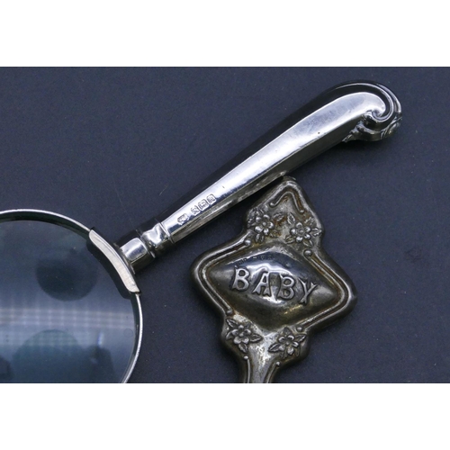 300 - A Sheffield silver handled table magnifying glass and a Chester silver baby's rattle with Mother of ... 