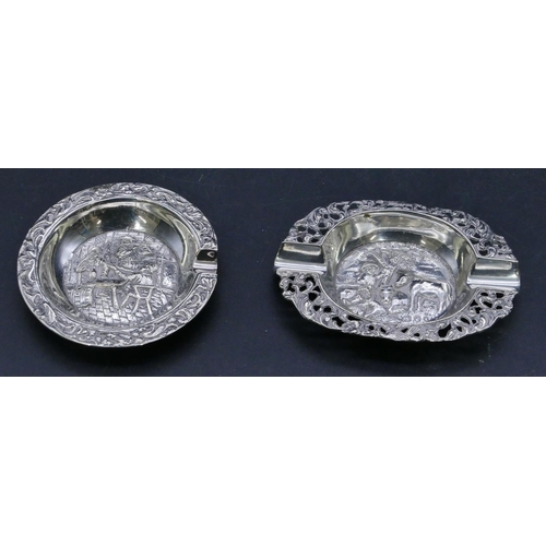 303 - 2 Continental silver coloured metal small ashtrays with embossed figure decoration, largest 7.5cm wi... 