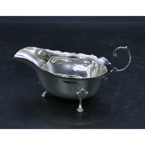 313 - A Birmingham silver sauce boat with crinkled rim, scroll handle on splayed hoof feet, 3oz.