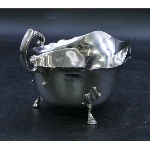 313 - A Birmingham silver sauce boat with crinkled rim, scroll handle on splayed hoof feet, 3oz.