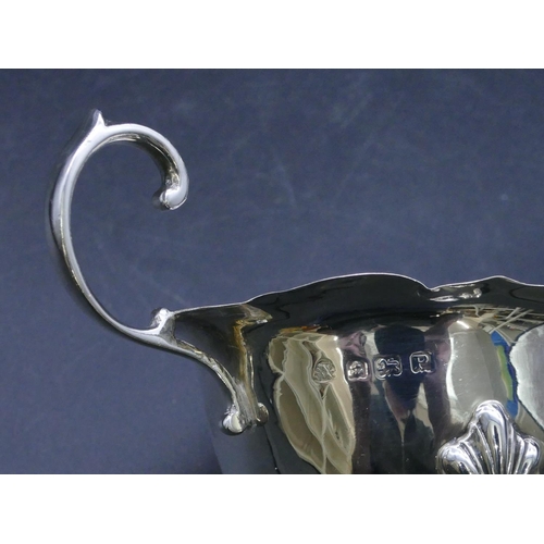 313 - A Birmingham silver sauce boat with crinkled rim, scroll handle on splayed hoof feet, 3oz.