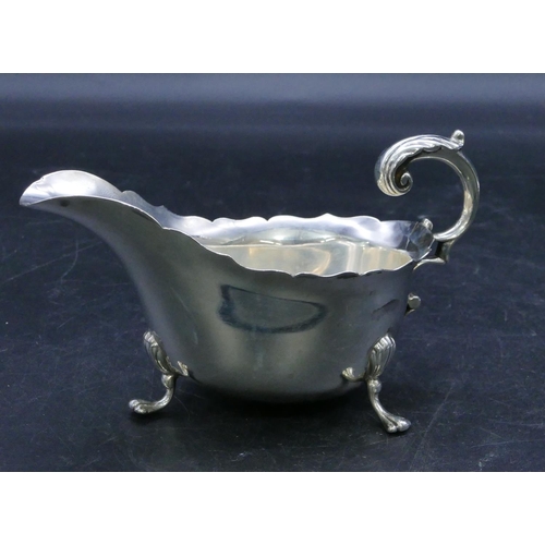 317 - A Sheffield silver sauce boat with crinkled rim, scroll handle, on splayed feet (foot missing), 5.1o... 