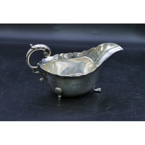 317 - A Sheffield silver sauce boat with crinkled rim, scroll handle, on splayed feet (foot missing), 5.1o... 