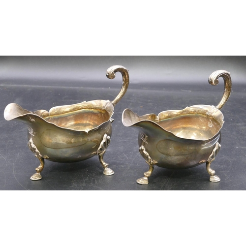 362 - A pair of early Victorian silver sauce boats engraved with crests and with crinkled rims, scroll han... 