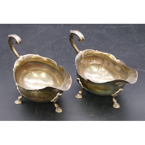 362 - A pair of early Victorian silver sauce boats engraved with crests and with crinkled rims, scroll han... 