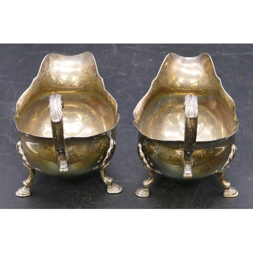 362 - A pair of early Victorian silver sauce boats engraved with crests and with crinkled rims, scroll han... 