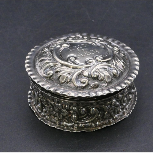 369 - A late Victorian silver round pill box with hinged lid and all over embossed floral and scroll decor... 