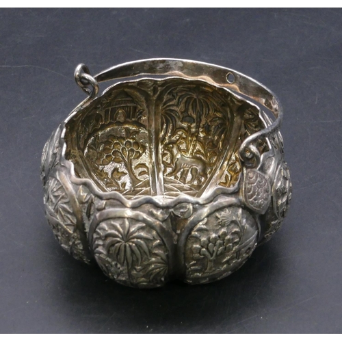 371 - An Eastern silver coloured metal round bulbous shaped sugar bowl with swing overhead handle, all ove... 