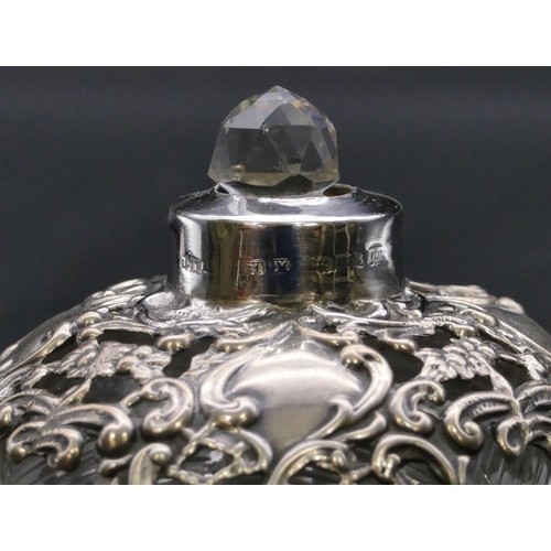 373 - A Edward VII cut glass round bulbous shaped scent bottle with silver embossed neck and cover enclosi... 