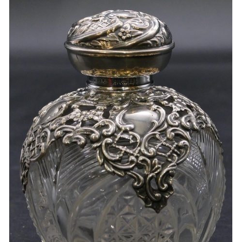 373 - A Edward VII cut glass round bulbous shaped scent bottle with silver embossed neck and cover enclosi... 