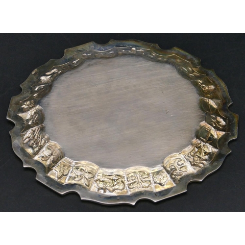 377 - A Continental silver coloured metal round pie crust card tray with embossed figure and animal motifs... 