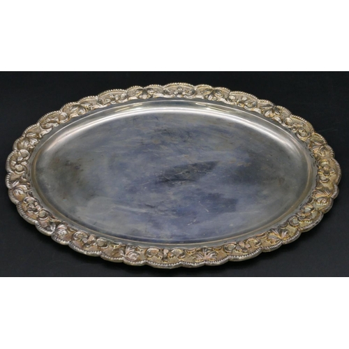 379 - An oval Continental silver coloured metal scallop shaped dish with embossed floral and scroll rim, 2... 