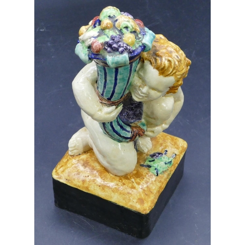 39 - Jess Lawson Peacey, glazed pottery figure of a seated cupid holding cornucopia with multi-coloured d... 