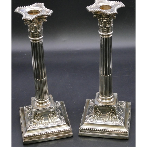 394 - A pair of Victorian silver Corinthian column candlesticks with embossed square sweeping bases, Sheff... 