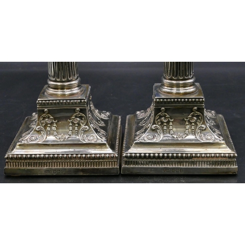 394 - A pair of Victorian silver Corinthian column candlesticks with embossed square sweeping bases, Sheff... 