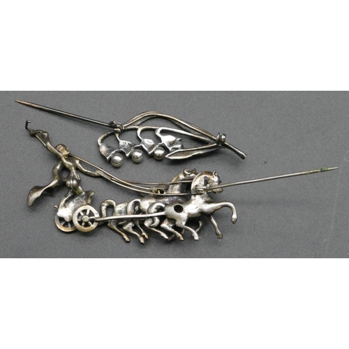 423 - A silver coloured metal and cut steel brooch in the form of a horse drawn chariot, 6.5cm long, anoth... 