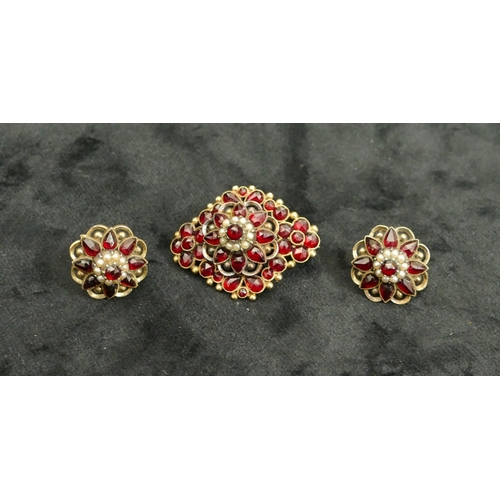 444 - A 9ct gold garnet brooch mounted with half pearls, 4cm long and a pair of matching screw earrings, o... 