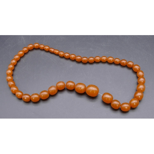 445 - An amber style graduated bead necklace.