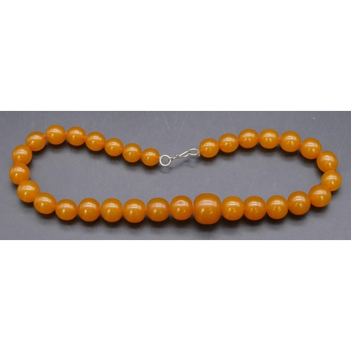 446 - An amber style graduated bead necklace.