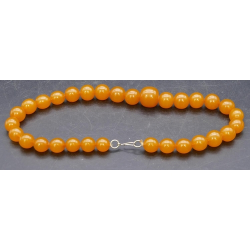 446 - An amber style graduated bead necklace.