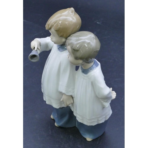 45 - A Nao figure of 2 standing choir boys holding a bell, 17.5cm high.