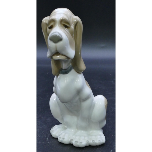 52 - A Nao figure of a seated dog on white and brown ground, 19cm high.