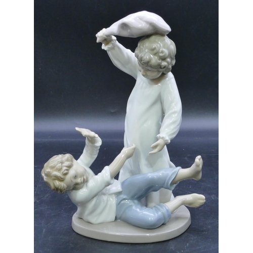 53 - A Nao group of a young girl and boy having a pillow fight, 24.5cm high.