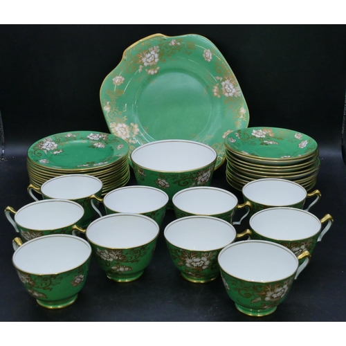 62 - A Crown Staffordshire tea service on green ground with white and gilt floral and leaf decoration, ca... 