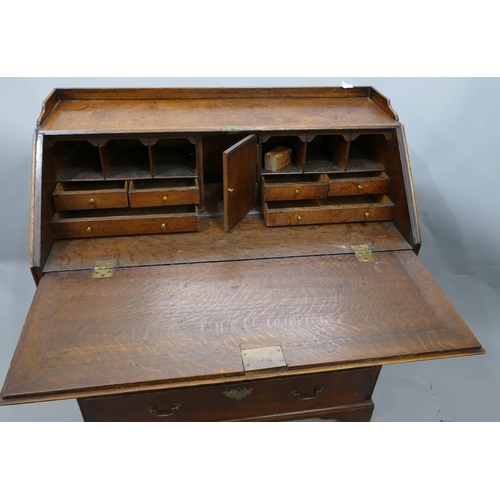 744 - A George III oak bureau with lipped gallery, full front enclosing fitted interior, 4 long graduated ... 