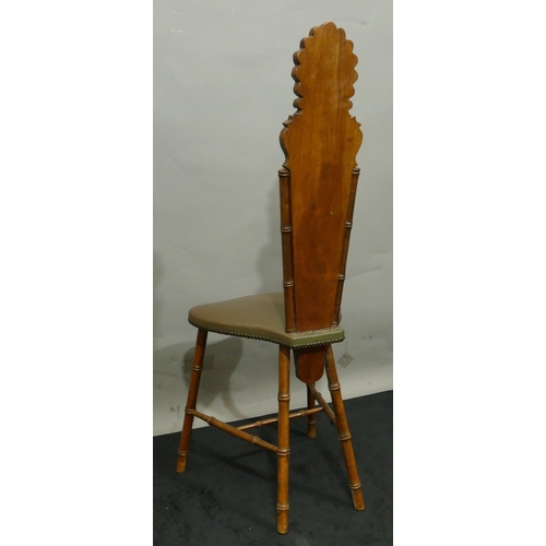 775 - A mahogany hall chair with a narrow carved back, leather overstuffed seat and part back on round tur... 