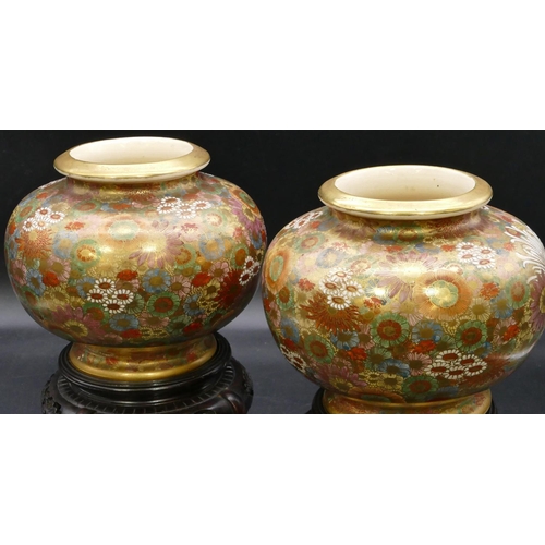 88 - A pair of signed satsuma round bulbous thin necked vases with hardwood stands, on multi-coloured gro... 