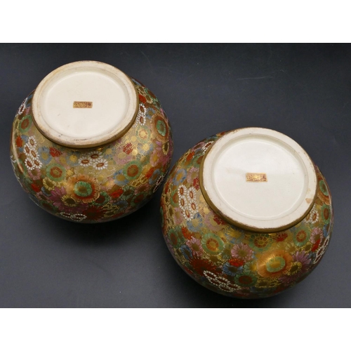 88 - A pair of signed satsuma round bulbous thin necked vases with hardwood stands, on multi-coloured gro... 