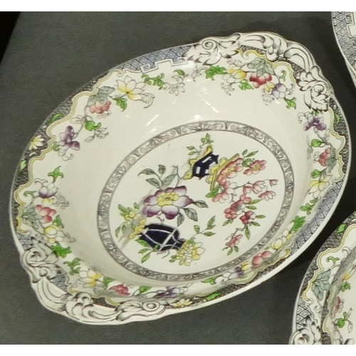 91 - A Mintons dinner service on white and black ground with multi-coloured vase, floral and scroll decor... 