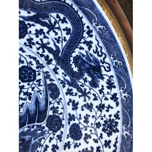 149 - A Chinese 18/19th Century Qianlong blue and white large charger with an allover dragon, floral, leaf... 