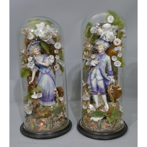 100 - A pair of Bisque china figures of gentleman and lady on blue and white ground, mounted under glass d... 