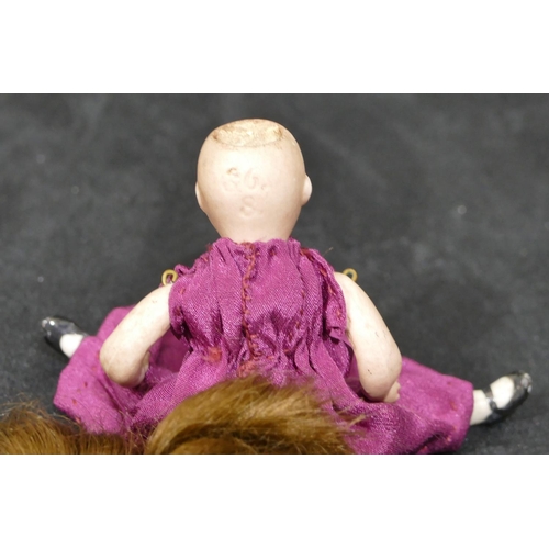 147 - A miniature porcelain doll with jointed body (hair loose), 9cm, a porcelain figure of a young lady a... 