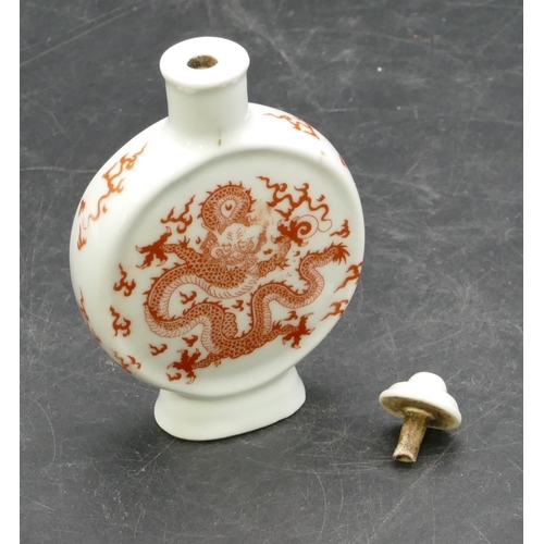 15 - An Oriental china balloon flask shaped snuff bottle with stopper on white ground with red dragon dec... 