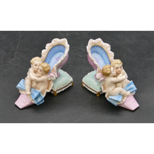 19 - A pair of 19th Century Meissen style groups of cupids seated in old shoe, 8.2cm high