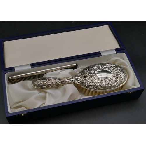 214 - A modern Birmingham silver dressing table brush with allover embossed figurehead, bird and scroll de... 