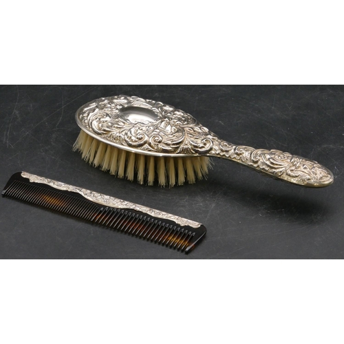 214 - A modern Birmingham silver dressing table brush with allover embossed figurehead, bird and scroll de... 