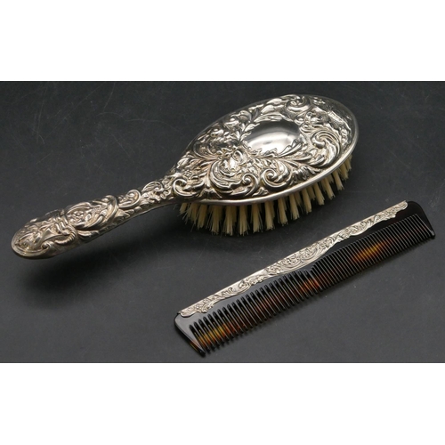 214 - A modern Birmingham silver dressing table brush with allover embossed figurehead, bird and scroll de... 