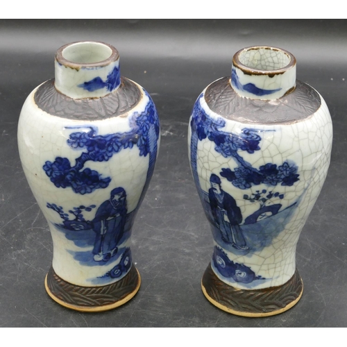 22 - A pair of Chinese round bulbous thin necked vases on blue and white ground with figure, tree and lan... 