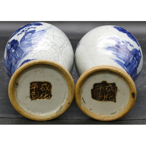 22 - A pair of Chinese round bulbous thin necked vases on blue and white ground with figure, tree and lan... 