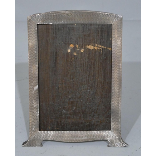 227 - A Birmingham silver freestanding photograph frame with engine turn decoration on splayed feet and oa... 