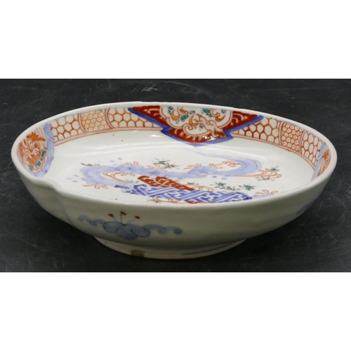 23 - An Imari oval bowl, bright red and blue ground with floral, leaf and scroll decoration, 18.8cm wide