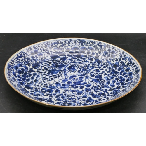 25 - An 18th Century Chinese round plate on blue and white ground with allover blossom decoration, 28.3cm... 