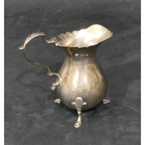 276 - A Britannia silver round bulbous shaped cream jug with crinkled rim, scroll handle and splayed hoof ... 