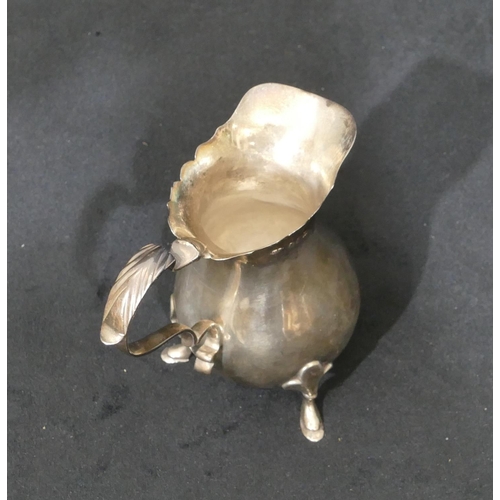 276 - A Britannia silver round bulbous shaped cream jug with crinkled rim, scroll handle and splayed hoof ... 